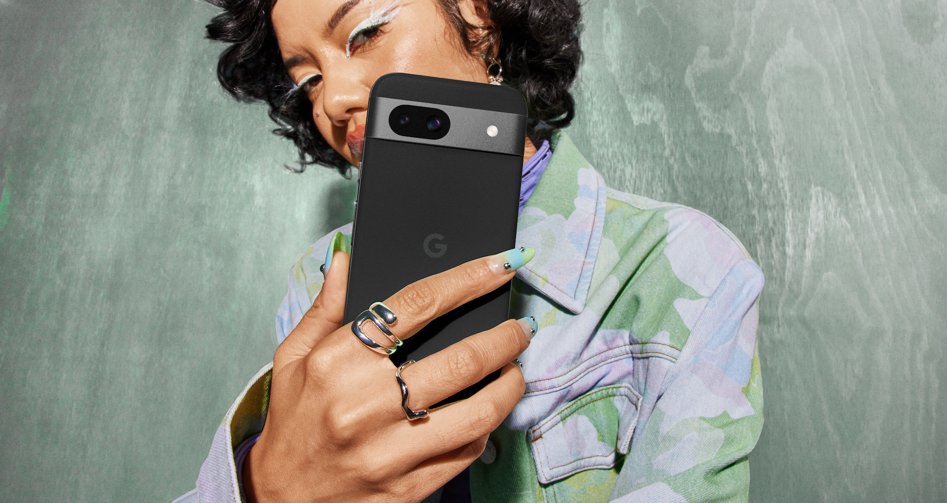 Stylish person holds a black Pixel 8a phone