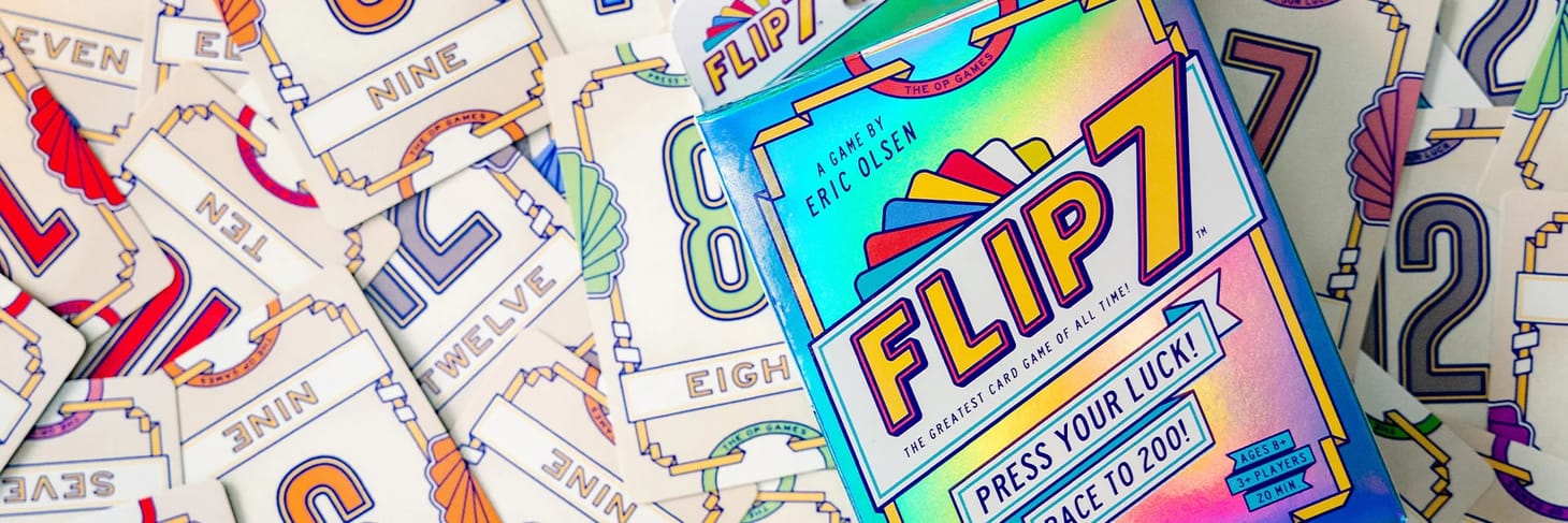 Flip7 cards are spread across a surface, with the Flip7 box sitting on top.