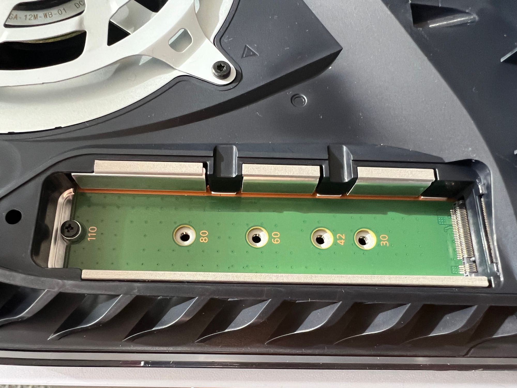 Under the expansion slot cover there is a little green well for the drive to be plugged in.